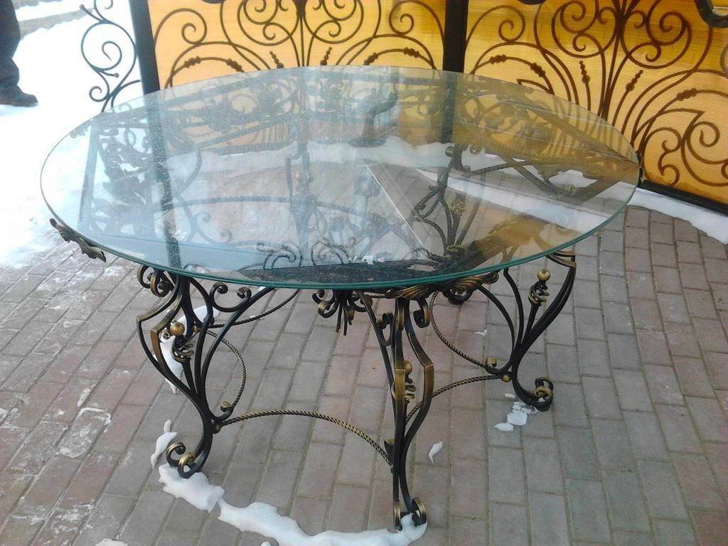 Фотография товара Кованый круглый стол cо стеклянной столешницей, витыми прутьями и раздвоенными патинированными опорами