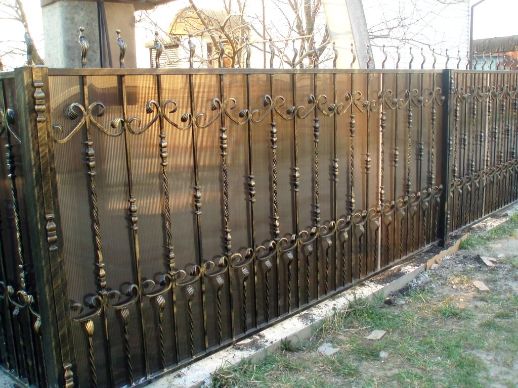 Фотография товара Кованый забор с поликарбонатом, витыми прутьями со вставками, узорами и фигурными навершиями