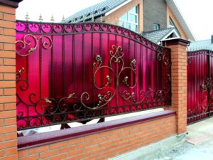 Фотография товара Кованый забор с розовым поликарбонатом, орнаментом, узорами с листвой и цветами и фигурными пиками
